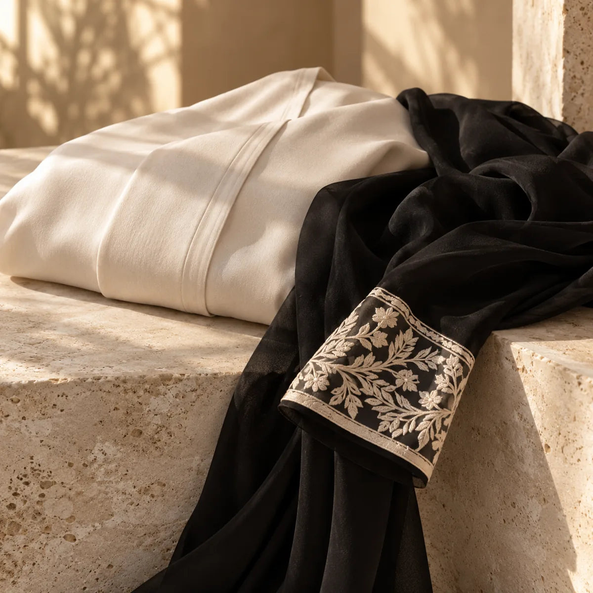 Ivory and black modest-wear fabrics with delicately embroidered cuffs.